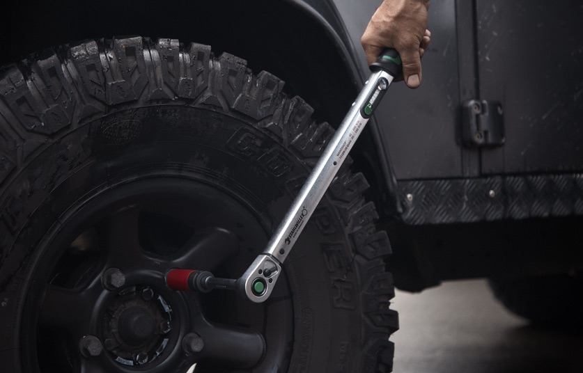 Hand benutzt Drehmomentwerkzeug an einem Automotive-Reifen