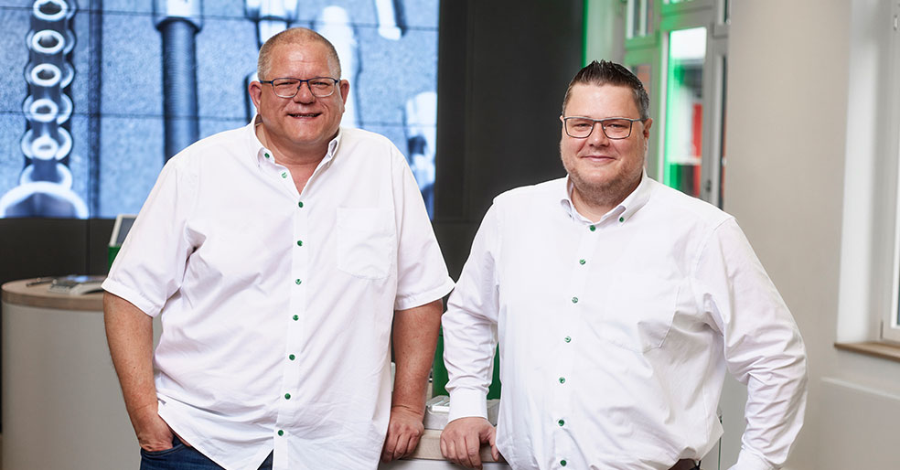 Die DAPTIQ® Ansprechpartner, Alexander Grosser und Timo Schmidt, schauen in die Kamera