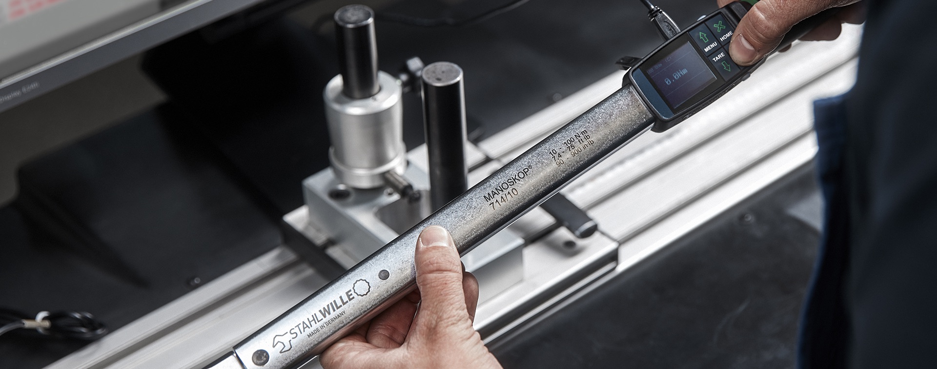 Employee adjusts torque wrench for calibration